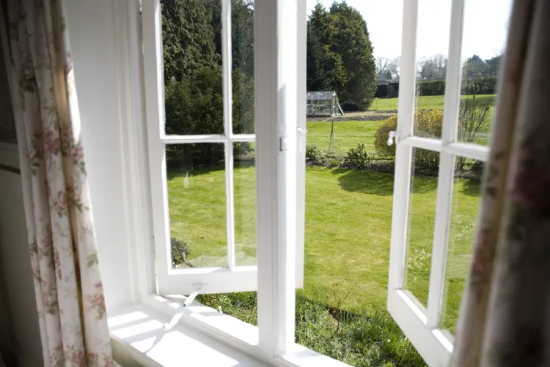 The garden and greenhouse seen through a cottage window